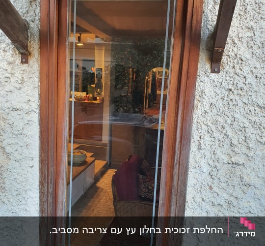 חלון זכוכית עם מסגרת עץ, משקף פנים בית